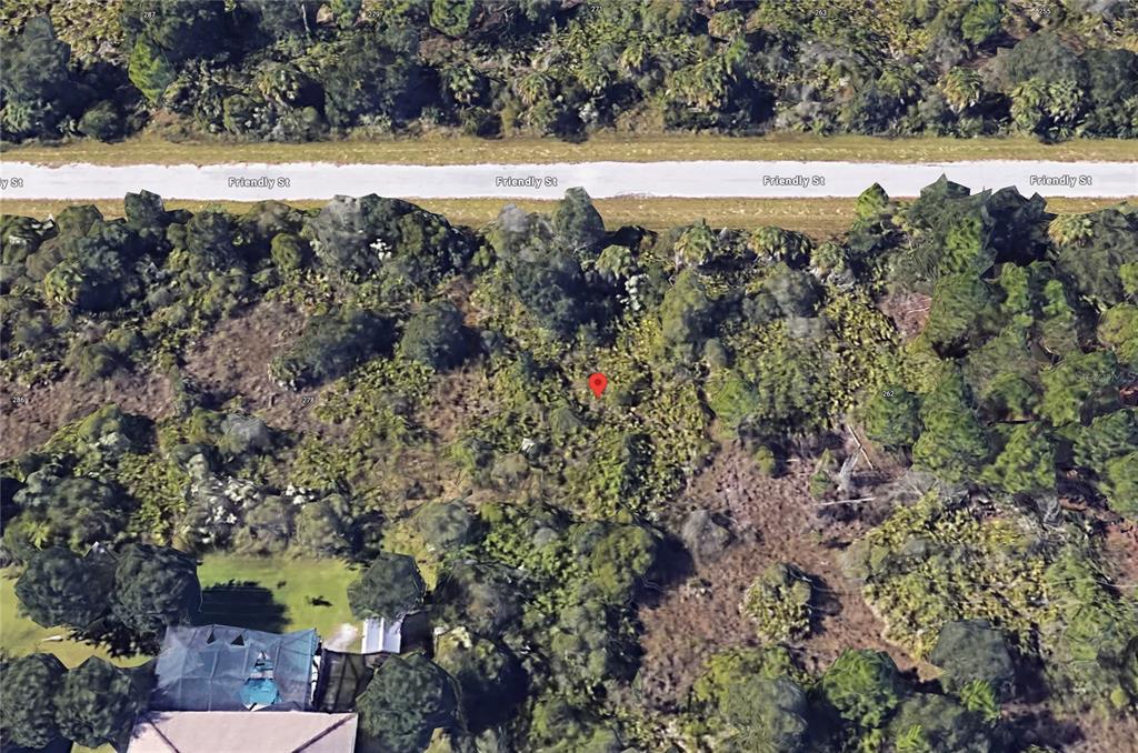 An aerial view shows a wooded, undeveloped lot marked with a red pin near a road — 270 FRIENDLY STREET, PORT CHARLOTTE, FL