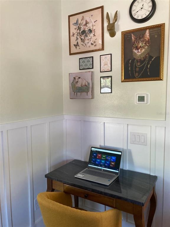 A small home office area features a desk, a yellow chair, and a gallery wall — 2408 HILLVIEW STREET, SARASOTA, FL
