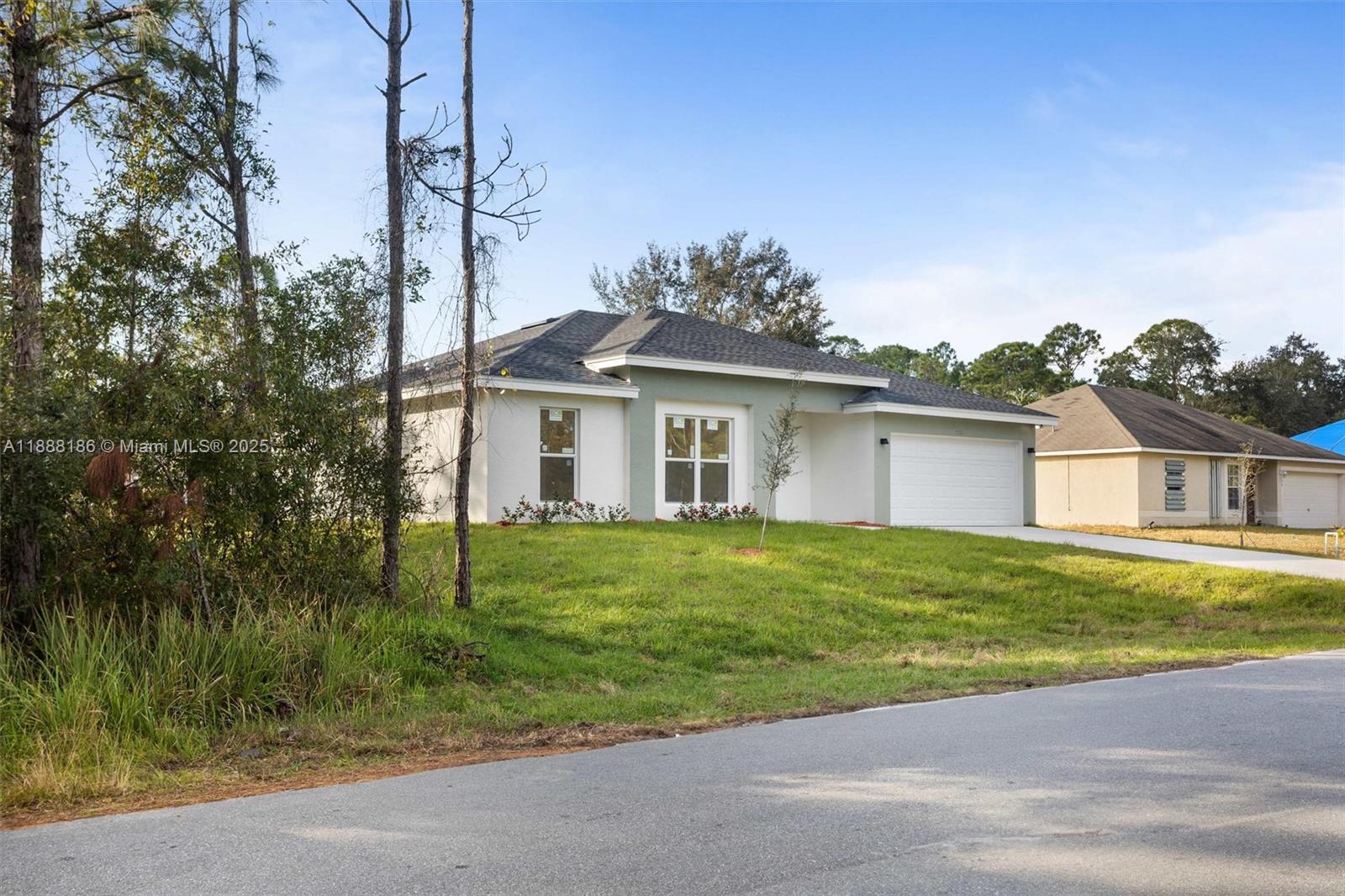 A single-story house with a white and light green exterior and a two-car garage — 1150 SE Tarleton St, Palm Bay FL 32909, PALM BAY, FL