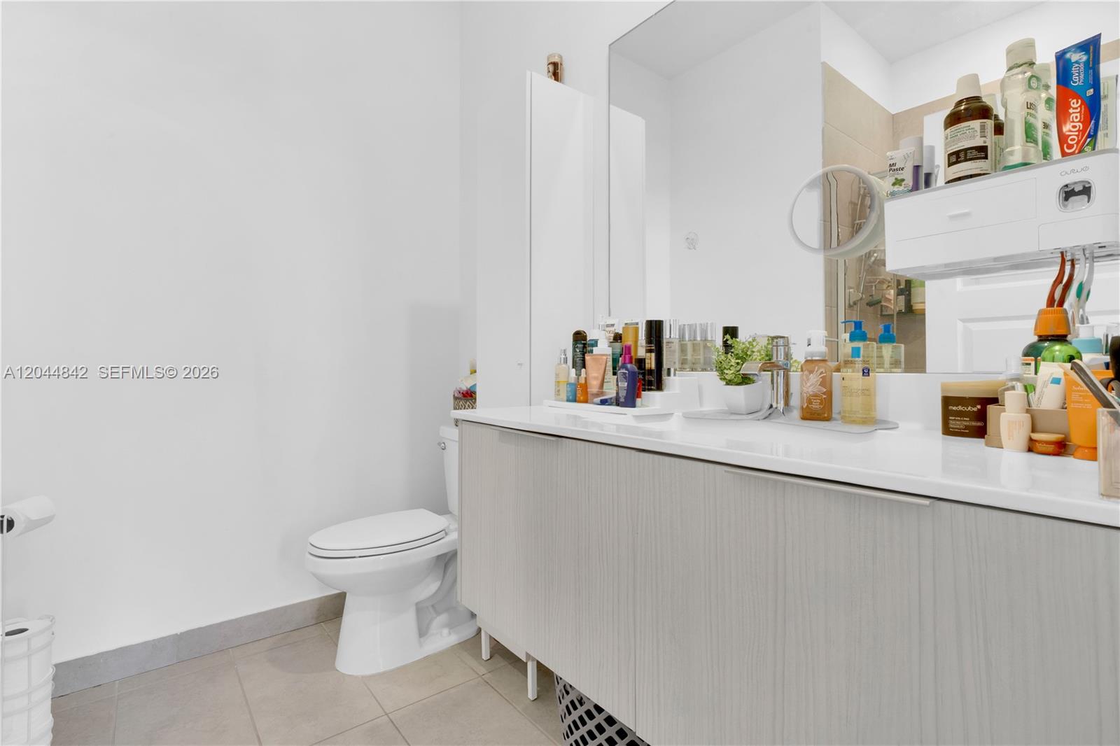 A bathroom features a white vanity with a light wood-grain cabinet and a toilet — 7819 NW 104th Ave # 23, Doral FL 33178, DORAL, FL