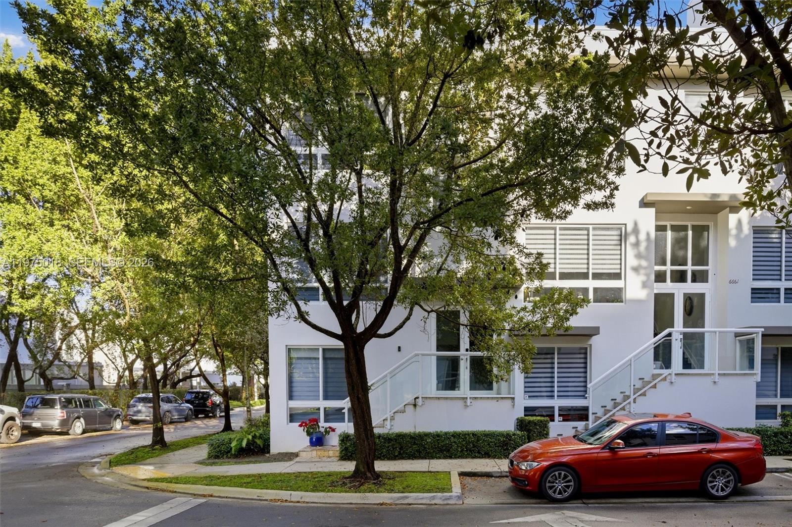 A modern white multi-story townhouse with glass-railed stairs and a red car parked outside — 6671 NW 105th Pl # 6671, Doral FL 33178, DORAL, FL