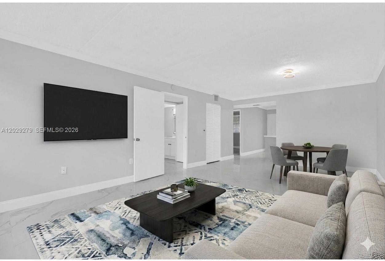 A living room features light gray walls, white tile flooring, a television, and dining area — 6135 NW 186th St # 202, Hialeah FL 33015, HIALEAH, FL