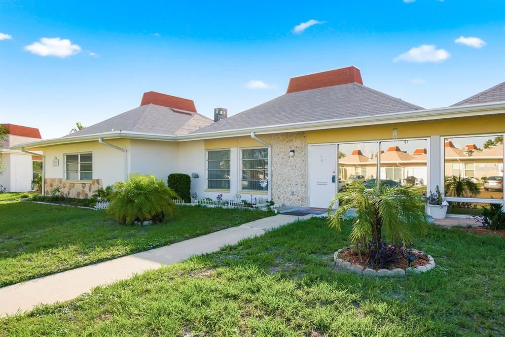 A single-story house with a white door, stone facade, and a hip roof — 4344 TAHITIAN GARDENS CIRCLE UNIT B, HOLIDAY, FL