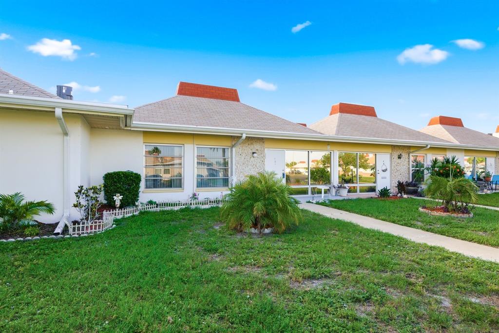 A row of single-story attached homes with tan walls, light-colored roofs, and small front lawns — 4344 TAHITIAN GARDENS CIRCLE UNIT B, HOLIDAY, FL