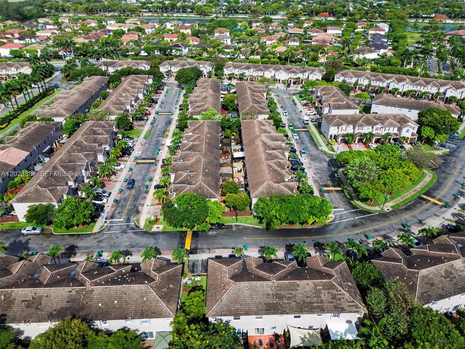 An aerial view shows multiple rows of townhouses with tiled roofs and surrounding green spaces — 9267 SW 220th Ter, Cutler Bay FL 33190, CUTLER BAY, FL