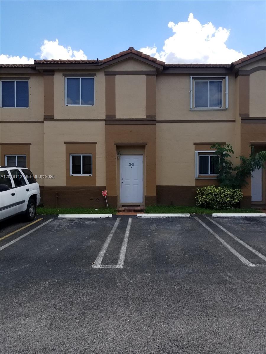 A two-story townhouse exterior features a white front door labeled 34 and parking spaces — 8394 SW 152nd Ave # 34, Miami FL 33193, MIAMI, FL