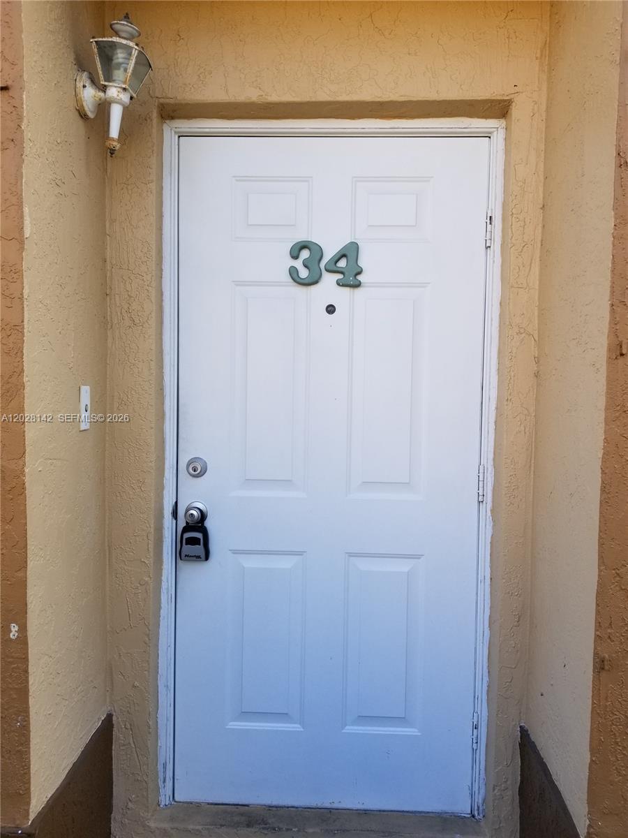 A white front door with the number 34 is set in a tan stucco wall — 8394 SW 152nd Ave # 34, Miami FL 33193, MIAMI, FL
