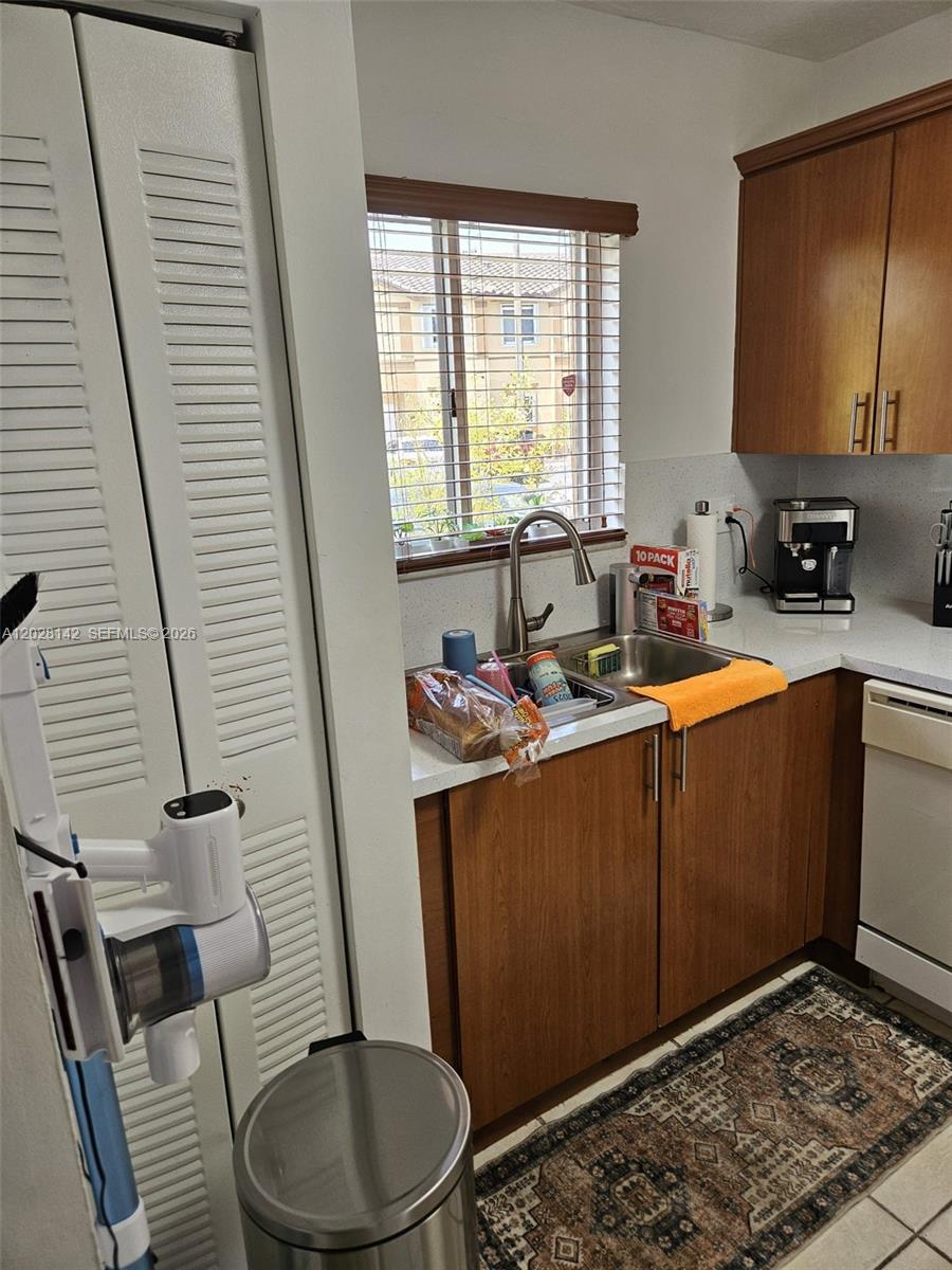 A kitchen features wood cabinets, a stainless steel sink, and a patterned area rug — 8394 SW 152nd Ave # 34, Miami FL 33193, MIAMI, FL