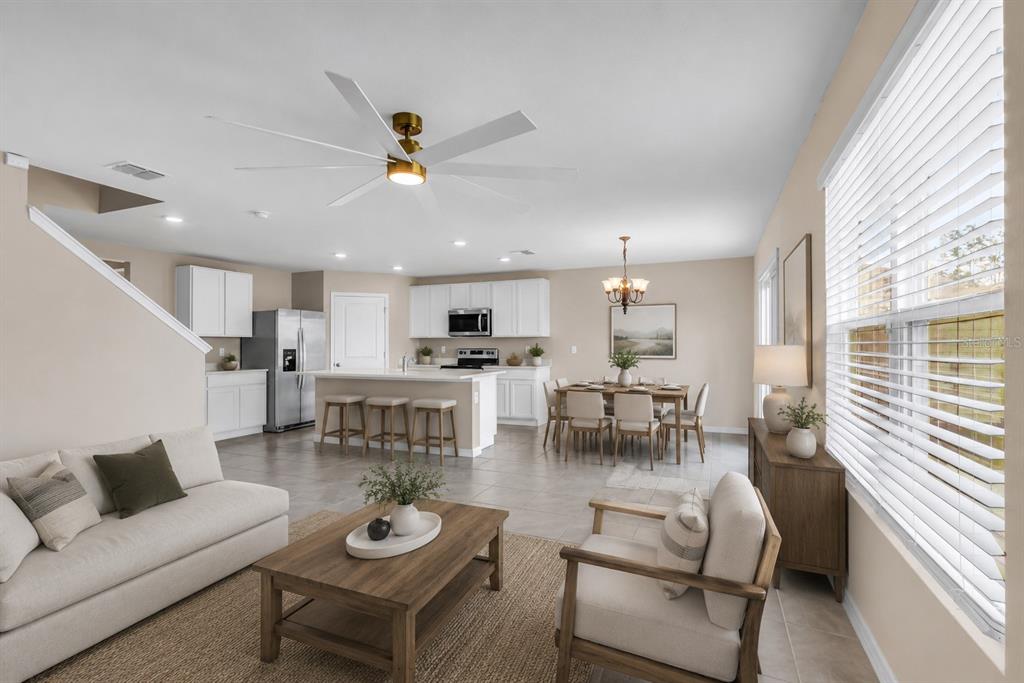 An open-concept living and dining area features tile flooring, white cabinetry, and a ceiling fan — 17627 NW 172ND AVENUE, ALACHUA, FL