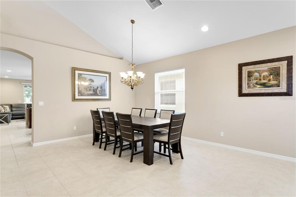 A dining room features a dark wood table with six chairs under a chandelier — 4284 RIVER BANK WAY, PUNTA GORDA, FL