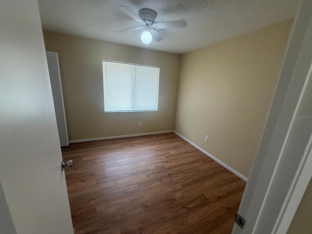 An empty bedroom features light-colored walls, a ceiling fan, and wood-look flooring — 213 S MOSS ROAD, WINTER SPRINGS, FL