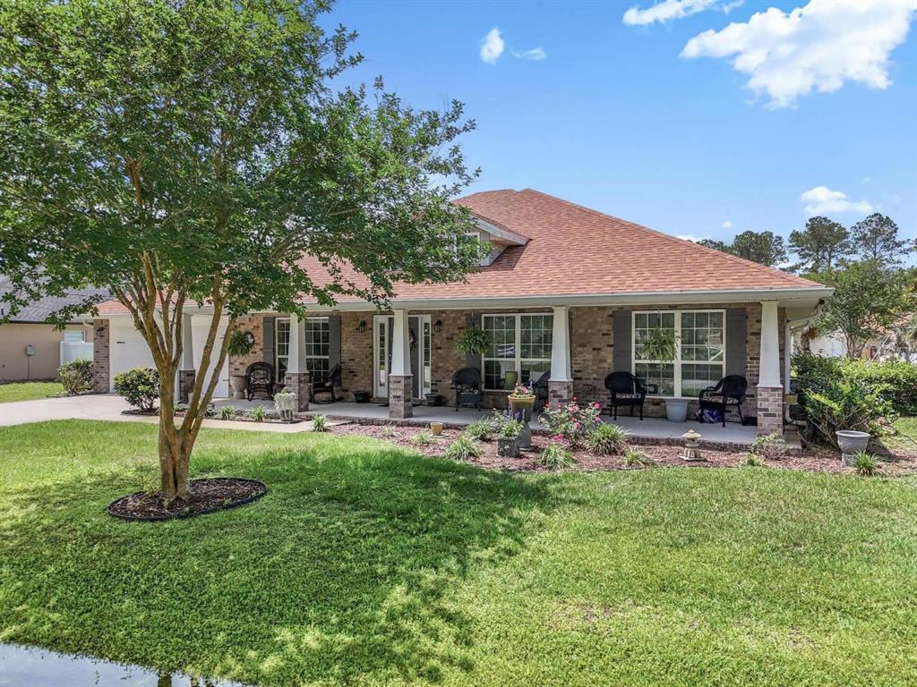 A single-story brick house with a covered front porch and a large front yard — 16 WHITE STAR DRIVE, PALM COAST, FL