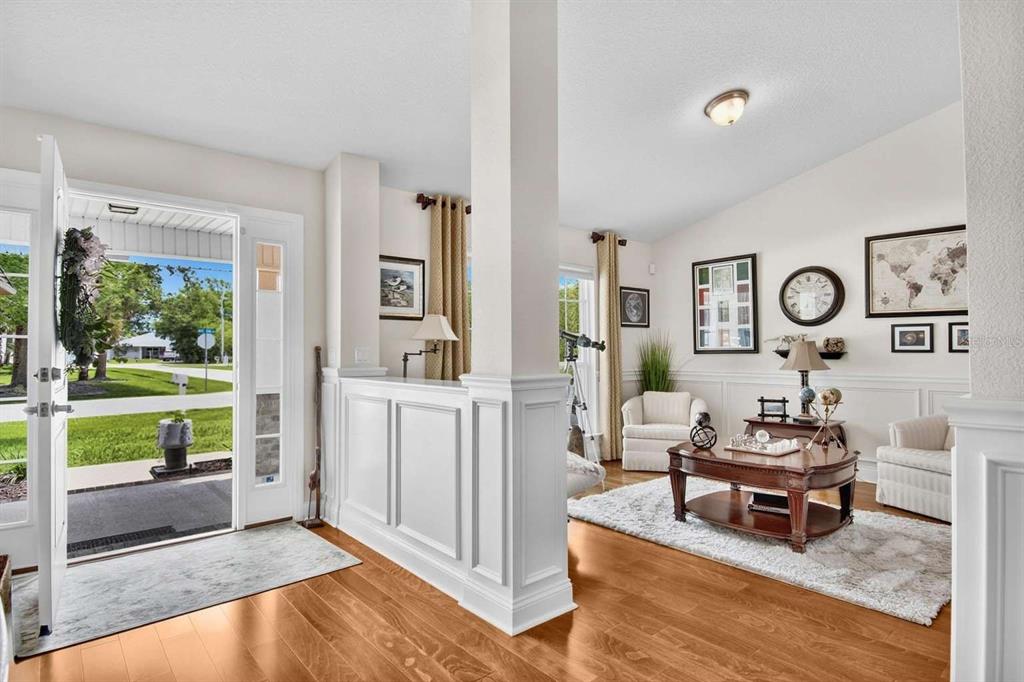 An entryway opens into a living room with hardwood floors, wainscoting, and a white pillar — 16 WHITE STAR DRIVE, PALM COAST, FL