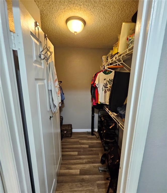 A walk-in closet features wood-look flooring, a ceiling light, and wire shelving for clothing storage — 4073 DIJON DRIVE UNIT 4073J, ORLANDO, FL
