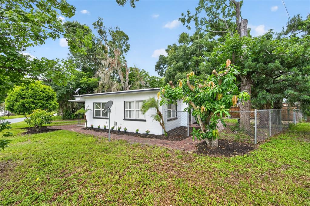 A white single-story house with a brick walkway and a chain-link fence in the yard — 1712 LAKE BROWN DRIVE, HAINES CITY, FL
