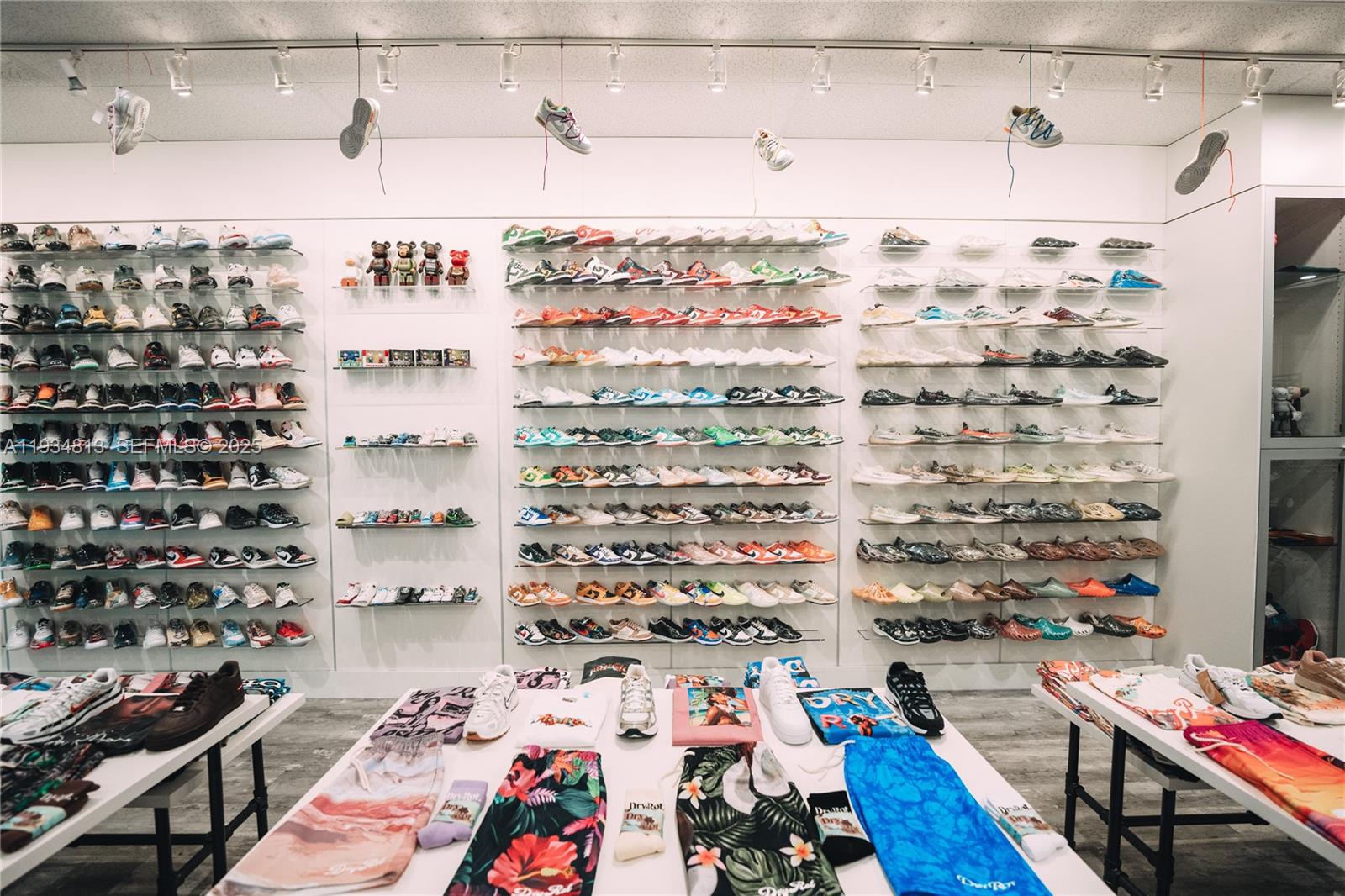 A retail store interior features shelves stocked with numerous sneakers and tables displaying apparel — 12700 SW 128th St #106, Miami FL 33186, MIAMI, FL