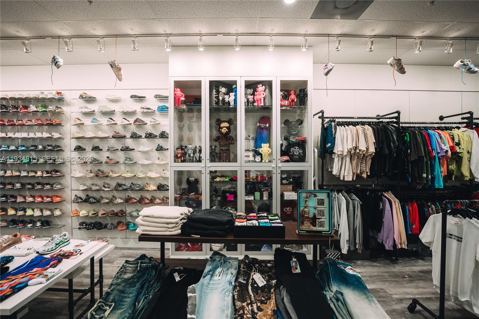 A retail store interior features shelves of sneakers, glass display cases, and racks of clothing — 12700 SW 128th St #106, Miami FL 33186, MIAMI, FL