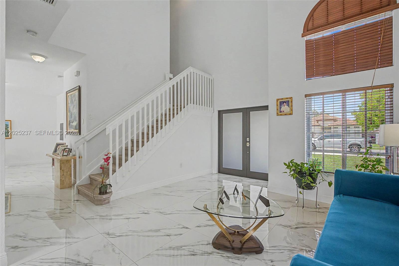 A bright entryway features white marble floors, a staircase with white railings, and double doors — 1551 SW 154th Ct, Miami FL 33194, MIAMI, FL