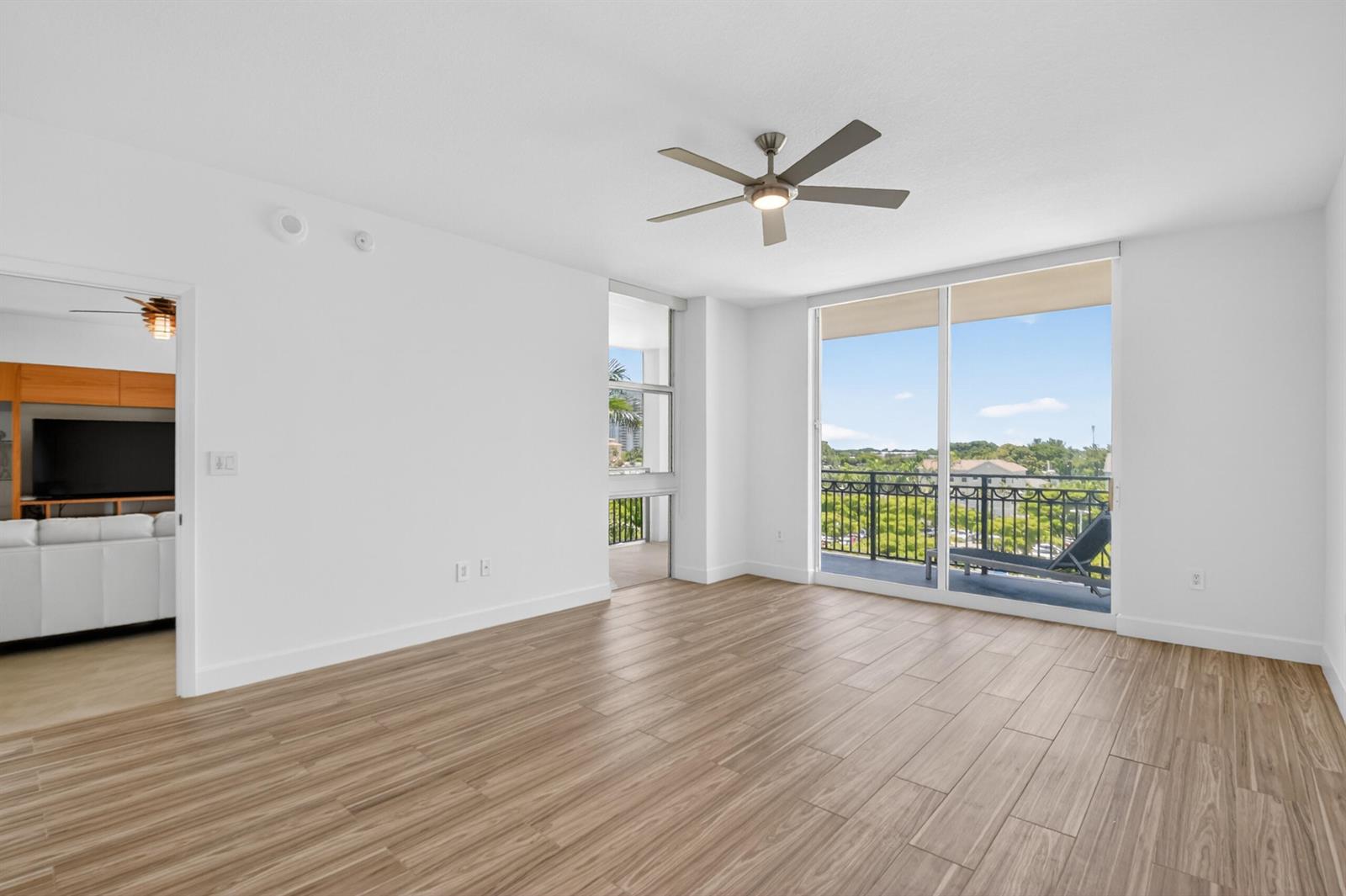 An empty room with wood-look tile flooring, a ceiling fan, and a sliding glass balcony door — 550 Okeechobee Boulevard # 423, West Palm Beach FL 33401, WEST PALM BEACH, FL