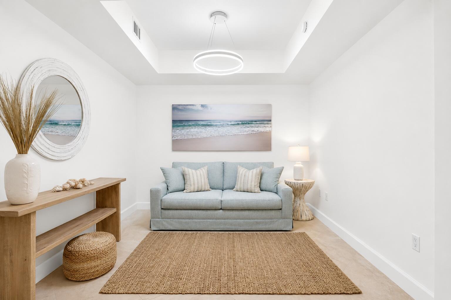 A bright sitting room features a light blue sofa, a wooden console table, and coastal decor — 550 Okeechobee Boulevard # 423, West Palm Beach FL 33401, WEST PALM BEACH, FL