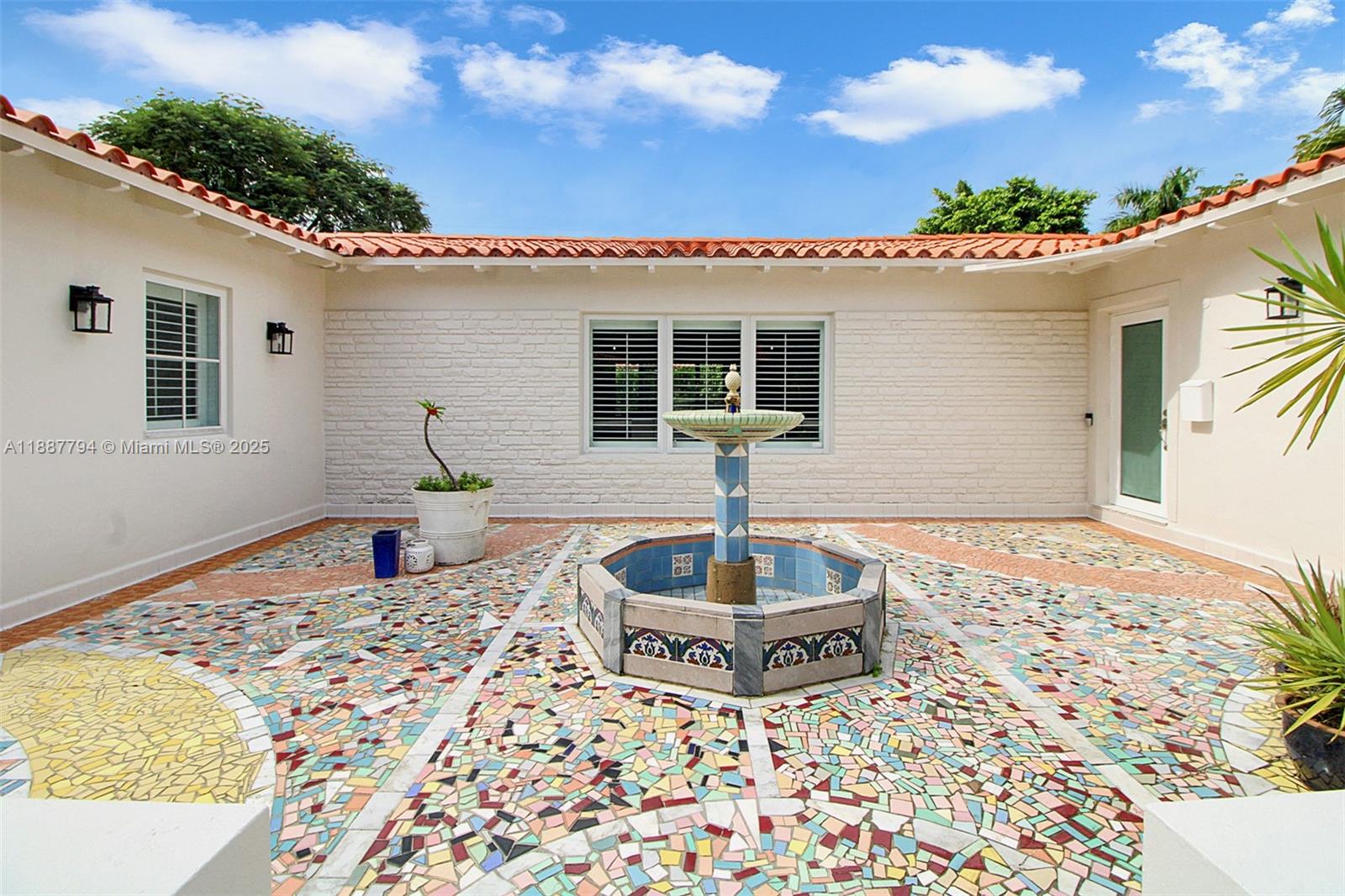 A courtyard features a central fountain, mosaic tile flooring, and white brick walls — 1110 Wallace St, Coral Gables FL 33134, CORAL GABLES, FL