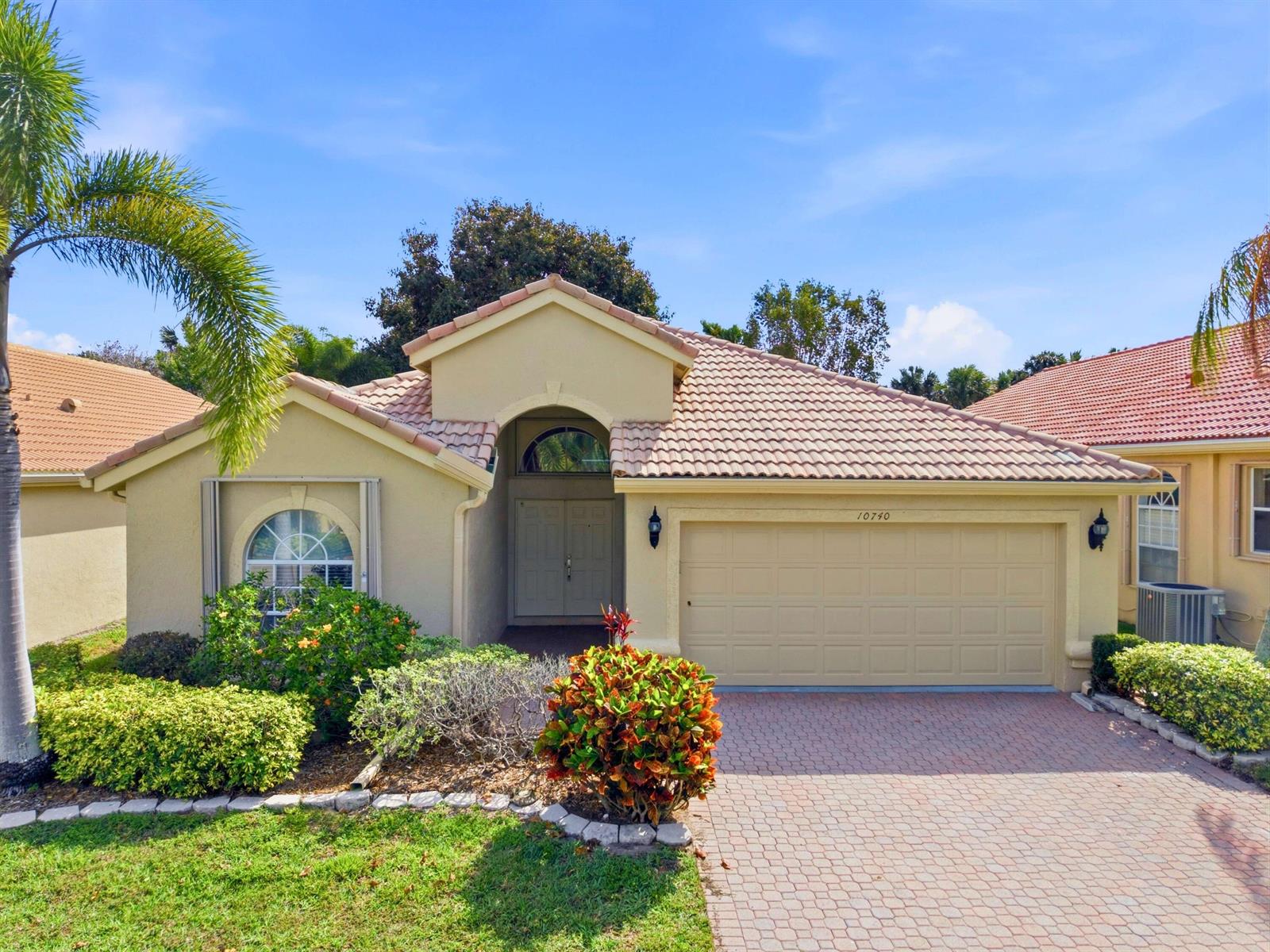 A single-story house with a beige stucco exterior, tile roof, and a paved driveway — 10740 Grande Palladium Way, Boynton Beach FL 33436, BOYNTON BEACH, FL