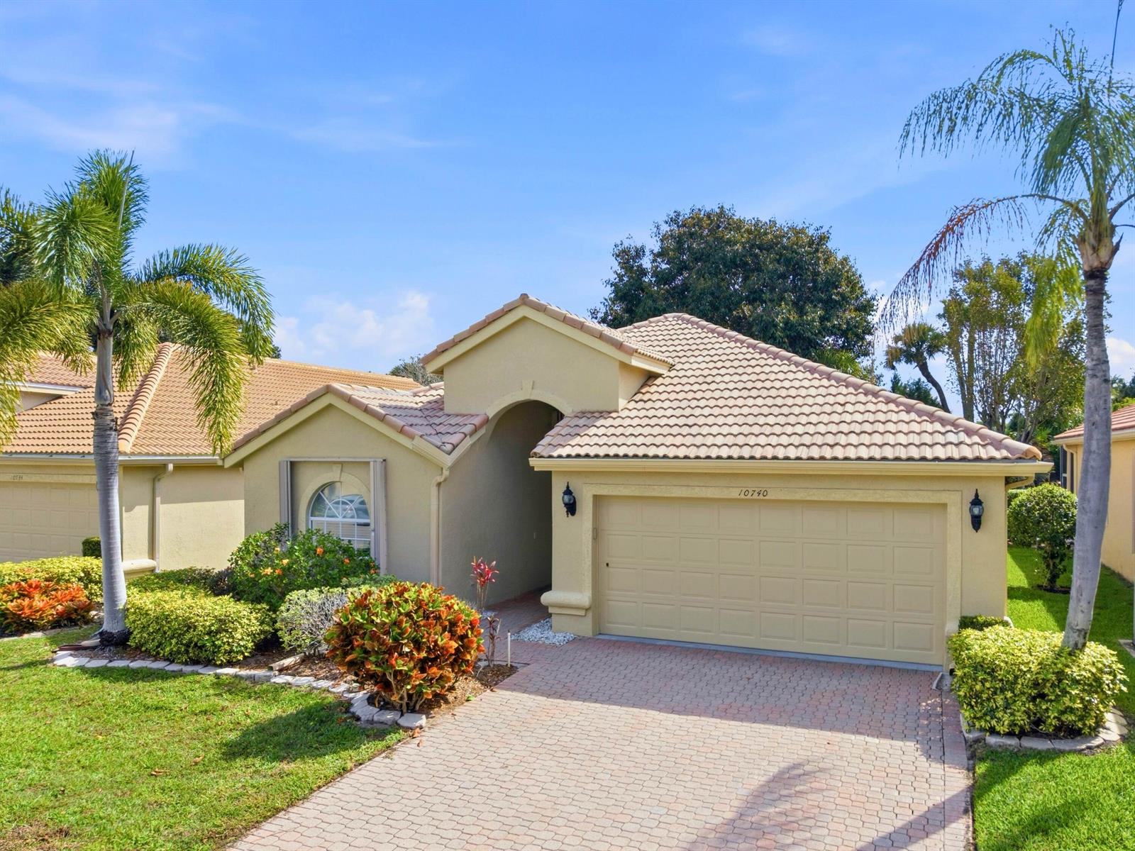 A single-story house with a beige stucco exterior, tile roof, and a paved driveway — 10740 Grande Palladium Way, Boynton Beach FL 33436, BOYNTON BEACH, FL