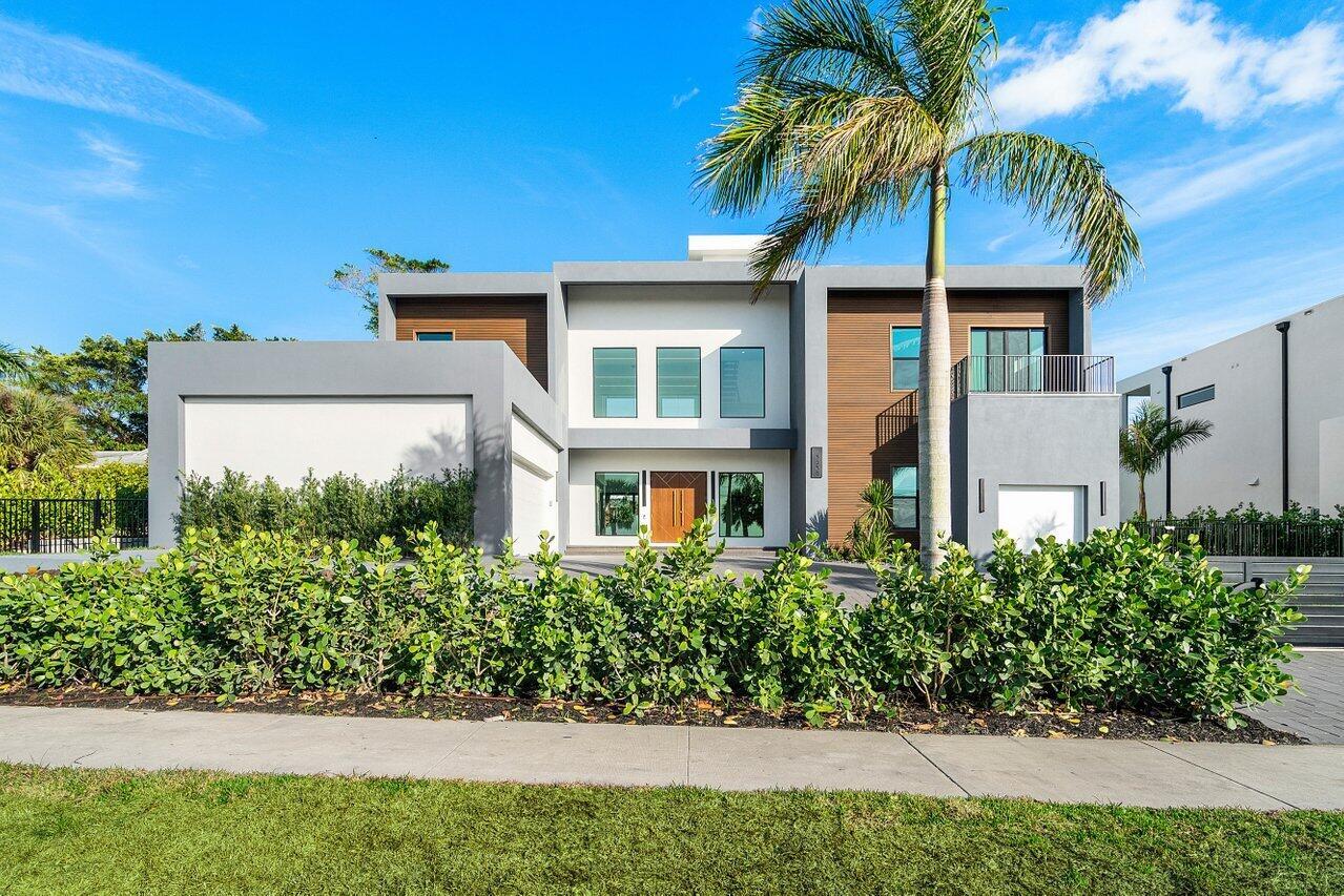 A modern two-story house with a gray and wood facade, a palm tree, and landscaping — 13480 Us Highway 1, Juno Beach FL 33408, JUNO BEACH, FL