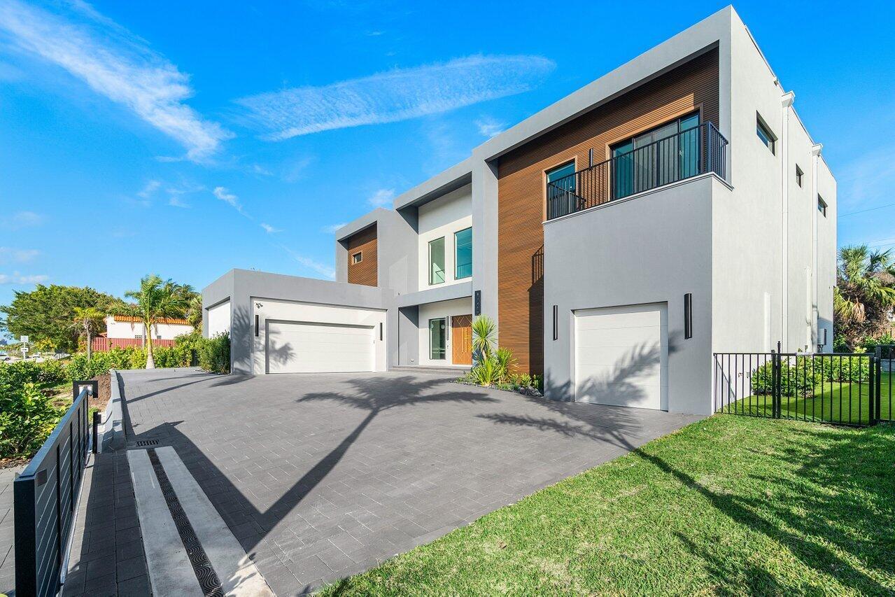 A modern two-story house with a gray exterior, wood accents, and a paved driveway — 13480 Us Highway 1, Juno Beach FL 33408, JUNO BEACH, FL
