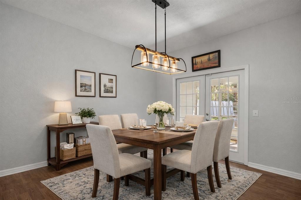 A dining room features a wooden table, six upholstered chairs, and a rectangular pendant light — 231 NE 28TH AVENUE UNIT 103, OCALA, FL
