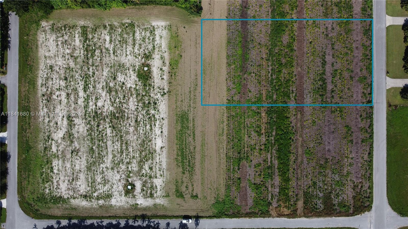 An aerial view shows a rectangular plot of land outlined in blue next to a road — 213th PL SW 240th ST, Miami FL 33031, MIAMI, FL