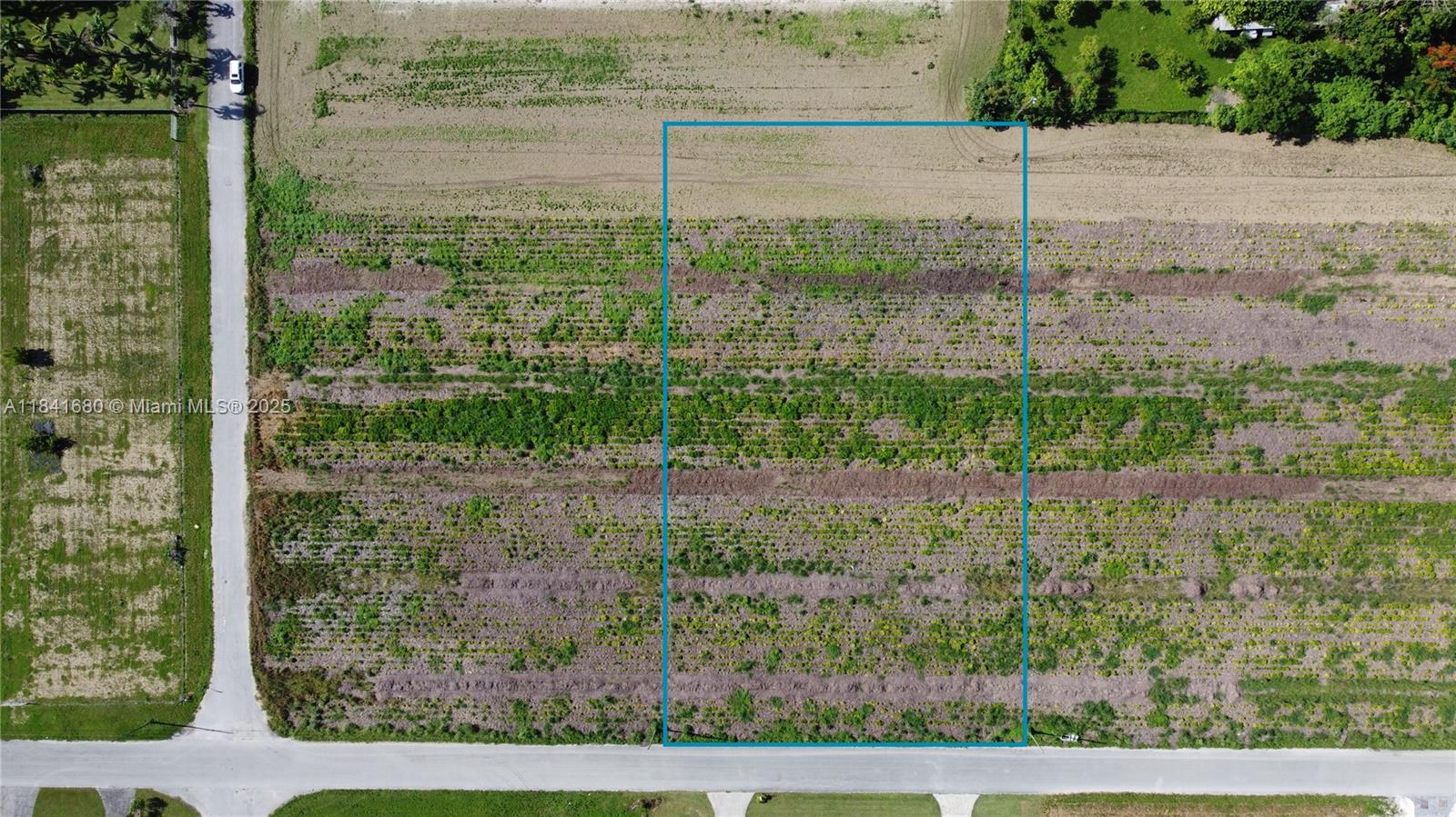 An aerial view shows a rectangular plot of land outlined in blue beside a road — 213th PL SW 240th ST, Miami FL 33031, MIAMI, FL