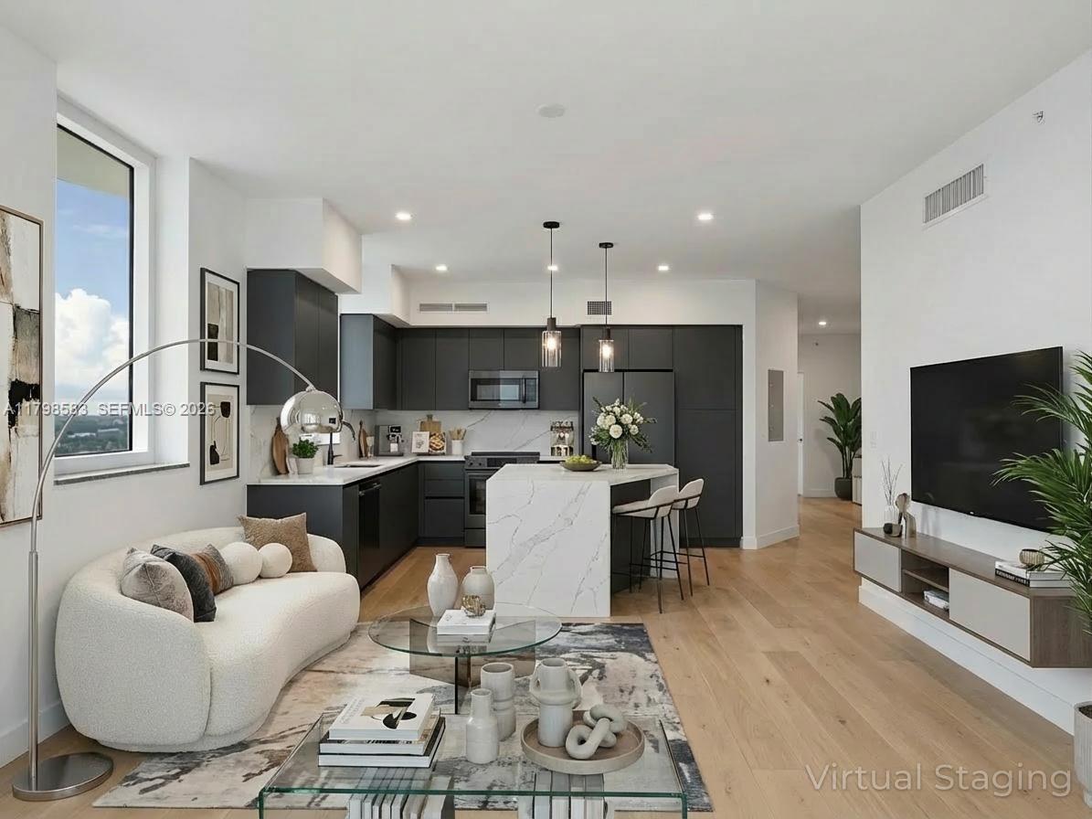 This virtual staging shows a modern open-concept kitchen and living room with dark cabinetry — 1745 E Hallandale Beach Blvd # 2007W, Hallandale Beach FL 33009, HALLANDALE BEACH, FL