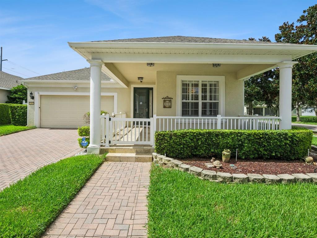 A single-story house with a paved driveway, front porch, and a white picket fence — 13403 RIGGS WAY, WINDERMERE, FL