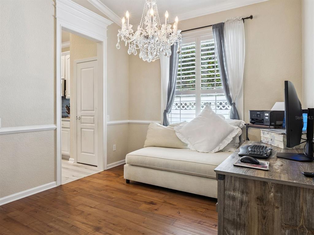 A home office features a daybed, a wooden desk, and a crystal chandelier — 13403 RIGGS WAY, WINDERMERE, FL