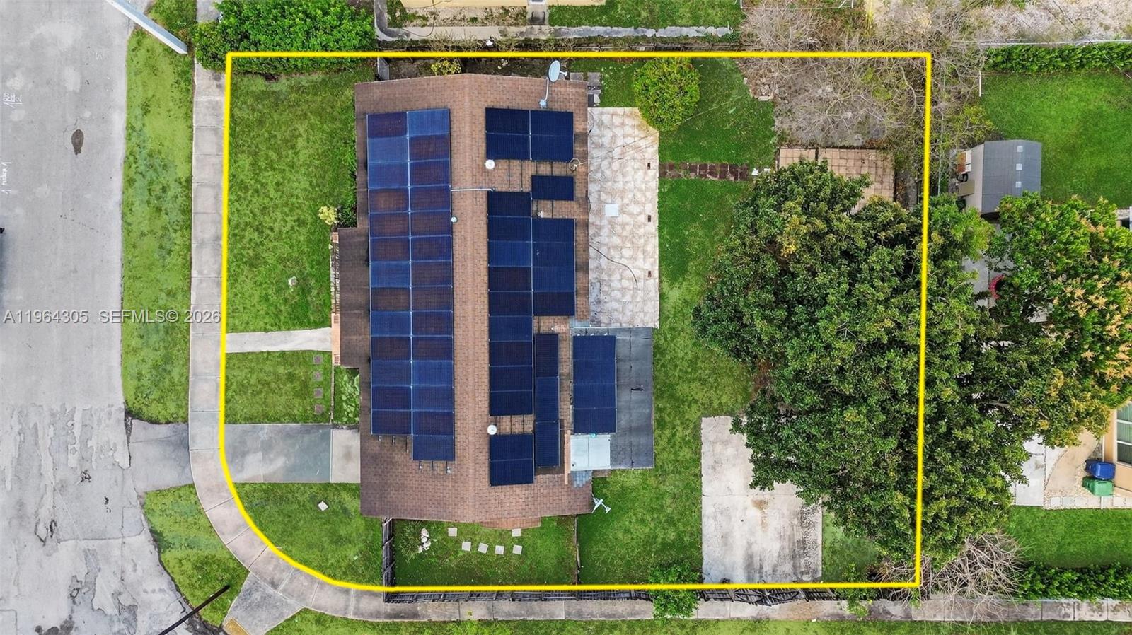 An aerial view shows a house with solar panels on the roof and a large tree — 1110 NE 204th Ter, Miami FL 33179, MIAMI, FL