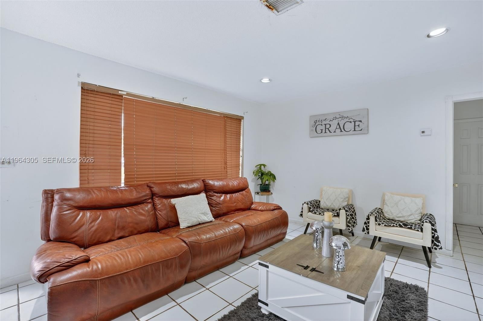 A living room features a brown leather sofa, two accent chairs, and a coffee table — 1110 NE 204th Ter, Miami FL 33179, MIAMI, FL
