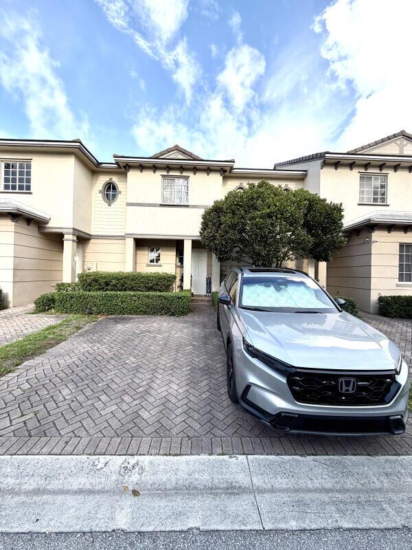 A silver Honda SUV is parked on a herringbone-patterned paver driveway in front of a townhouse — 1205 Abaco Lane, Riviera Beach FL 33404, RIVIERA BEACH, FL