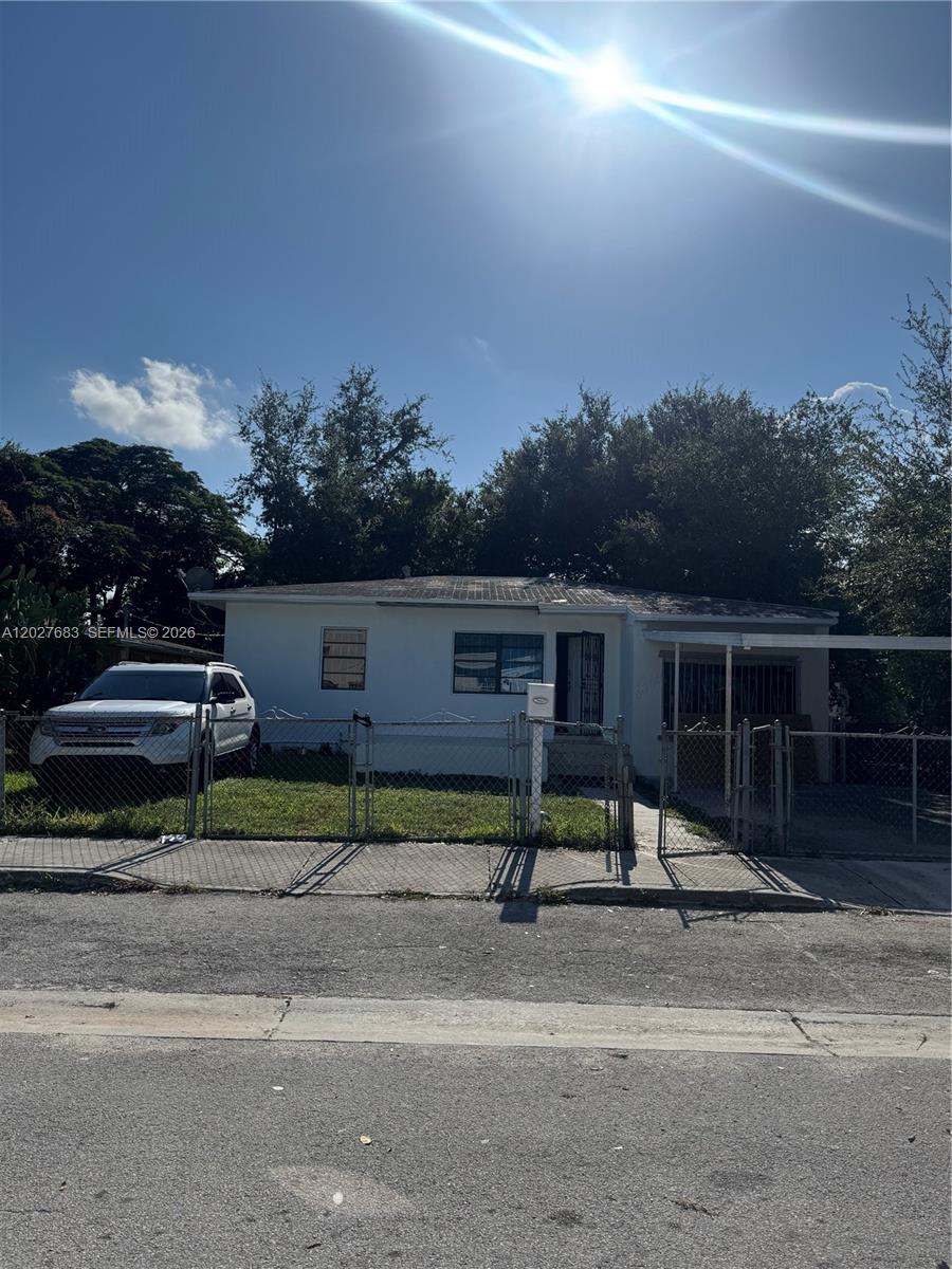 A single-story house with a white exterior, a chain-link fence, and a parked SUV — 6800 NW 2 CT, Miami FL 33150, MIAMI, FL