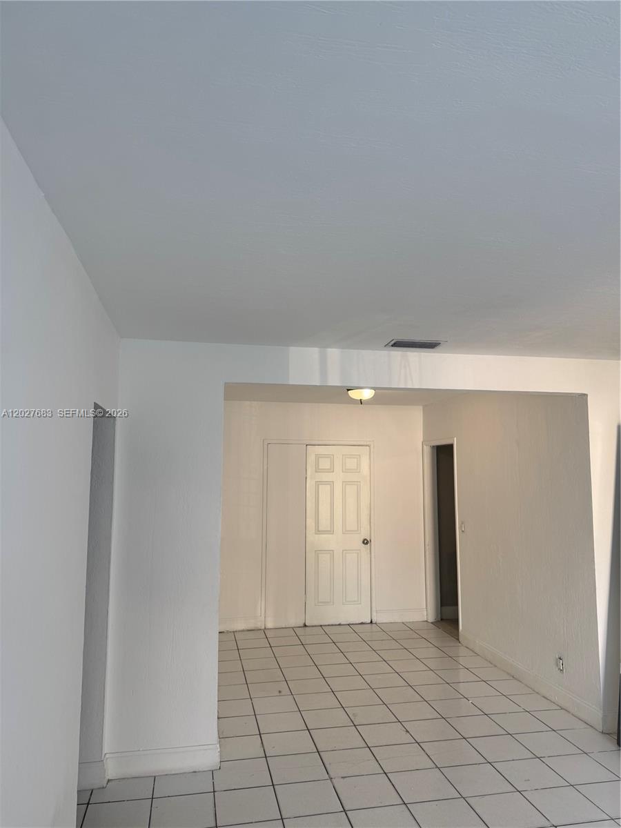 An interior view shows a tiled room with a white door and a doorway — 6800 NW 2 CT, Miami FL 33150, MIAMI, FL