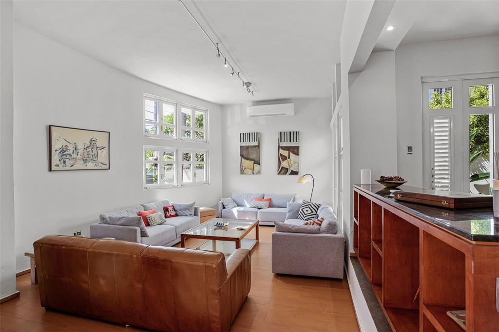 A living room features a leather sofa, light gray seating, a coffee table, and windows — 2003 ESPANA, SAN JUAN, PR