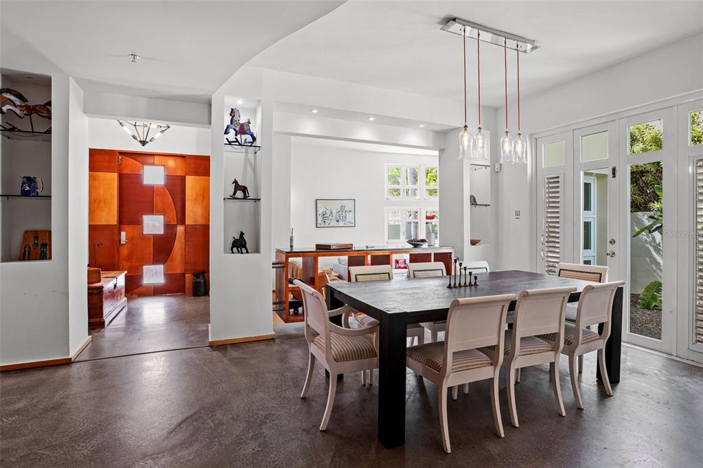A dining room with a dark wood table, light chairs, and a modern wooden door — 2003 ESPANA, SAN JUAN, PR