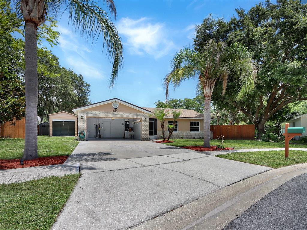 A single-story house with a garage, a concrete driveway, and palm trees in the front yard — 203 SWEETGUM, WINTER SPRINGS, FL