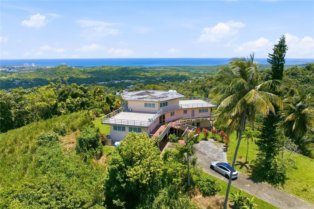 An aerial view of a multi-level house with a flat roof surrounded by lush greenery — 988 KM 1.5, LUQUILLO, PR