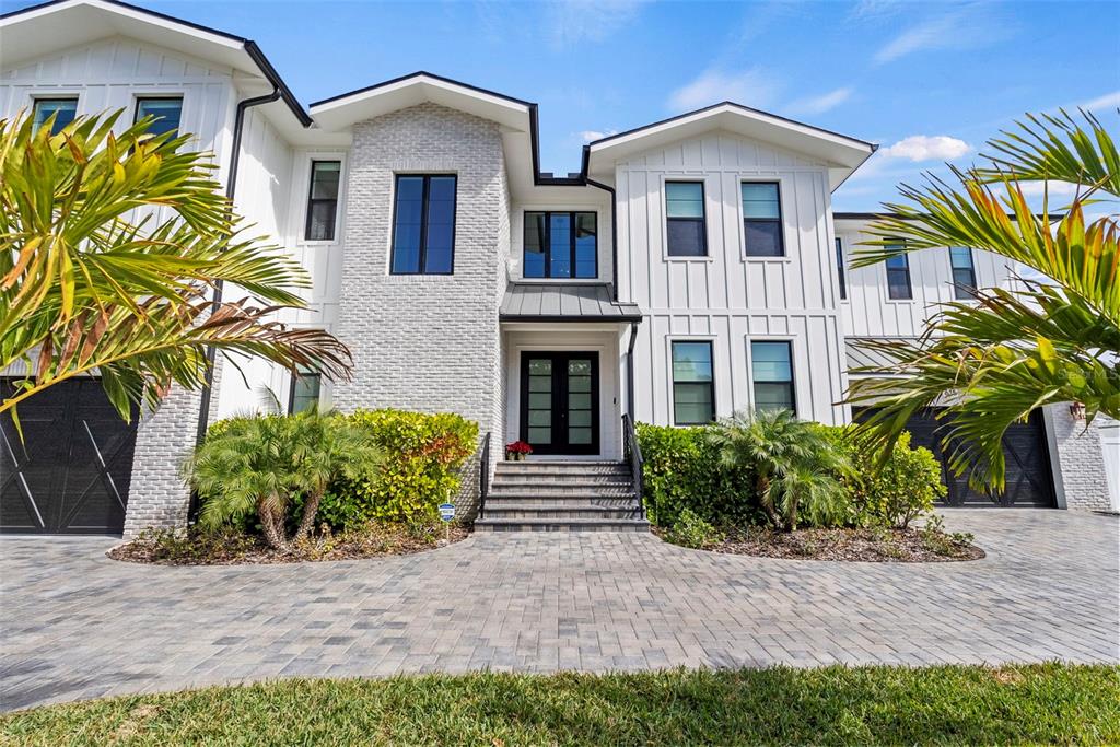 A two-story modern farmhouse with white siding, brick accents, and a paved driveway — 615 LUZON AVENUE, TAMPA, FL