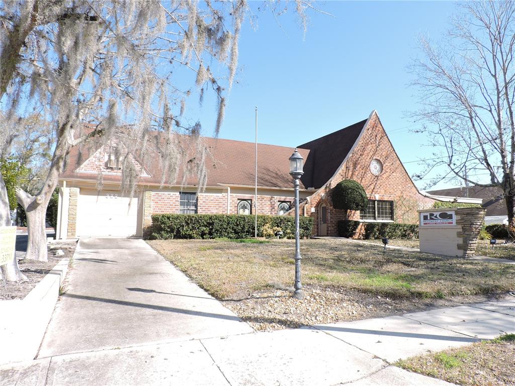 A brick building with a brown roof, a driveway, and a church sign on the lawn — 322 SCENIC HIGHWAY N, LAKE WALES, FL