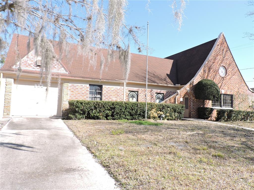 A brick house with a brown roof, a garage, and a front yard with hedges — 322 SCENIC HIGHWAY N, LAKE WALES, FL