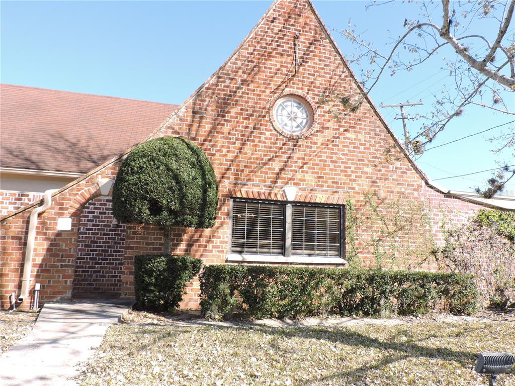 A brick house exterior features a circular window, a gabled roof, and manicured shrubs — 322 SCENIC HIGHWAY N, LAKE WALES, FL