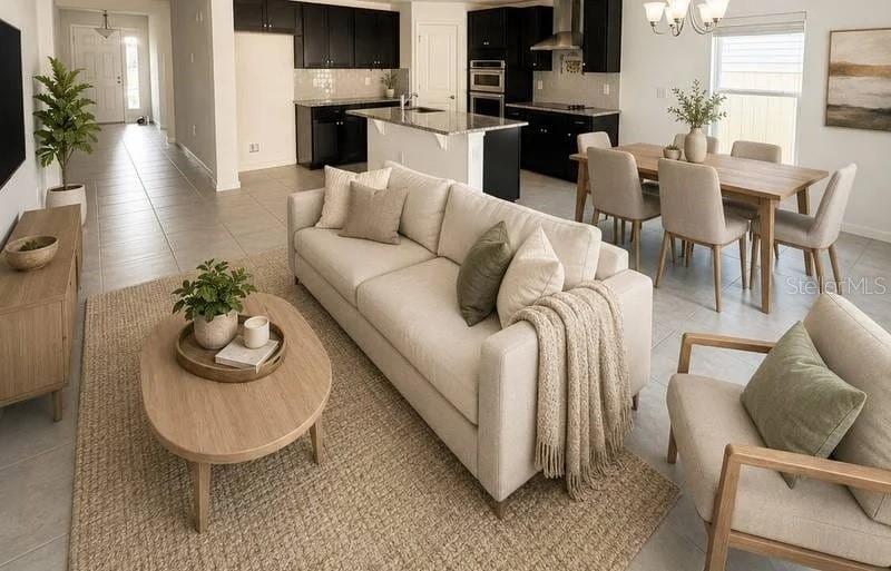 This open-concept living and dining area features a neutral color palette, tile flooring, and dark cabinetry — 3417 YARIAN DRIVE, HAINES CITY, FL