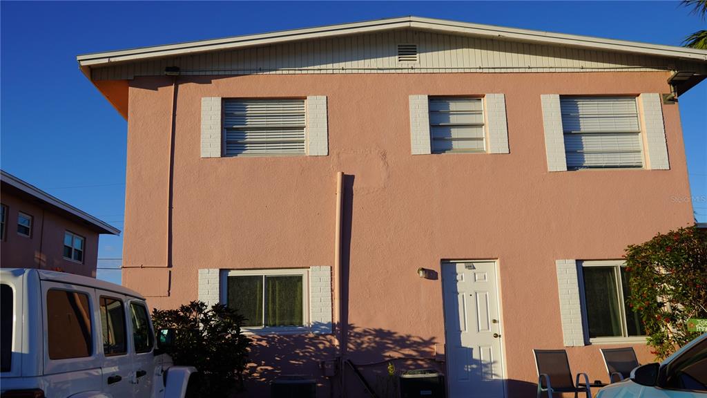 A two-story pink stucco building with a white door and several windows — 416 MONROE AVENUE UNIT F201, CAPE CANAVERAL, FL